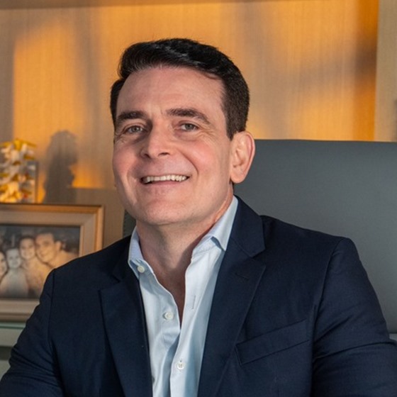 Dr. Marcelo Bianchin sorrindo em seu consultório